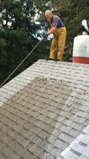 Professional roofer cleaning and treating residential roof in Salem Oregon
